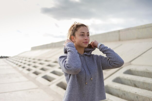 Porträt einer lockigen blonden Frau im Hoodie im Freien