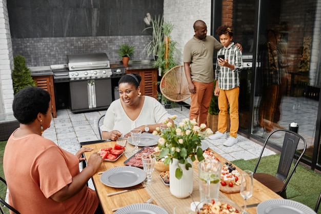 Porträt einer modernen afroamerikanischen Familie, die das Abendessen im Freien im Terrassenkopierraum genießt