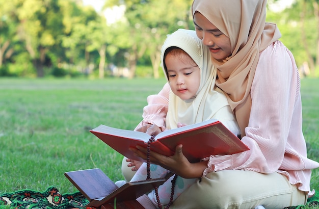 Porträt einer muslimischen Frau, die ihrer Tochter vorliest