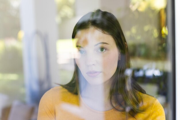 Foto porträt einer nachdenklichen kaukasischen frau, die durch ein fenster im kopierraum zu hause schaut