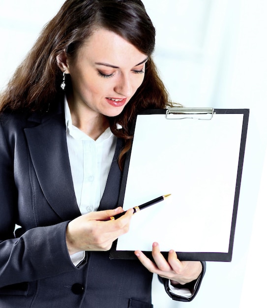 Porträt einer netten jungen Geschäftsfrau mit dem Arbeitsplan, der im Büro lächelt