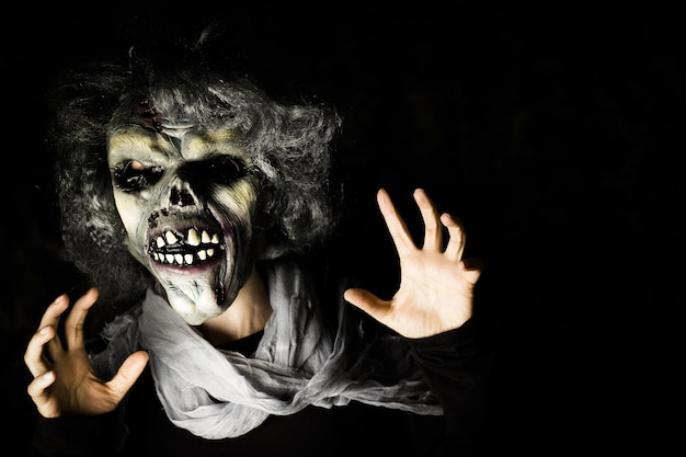 Foto porträt einer person mit einer bösen maske im dunkelzimmer