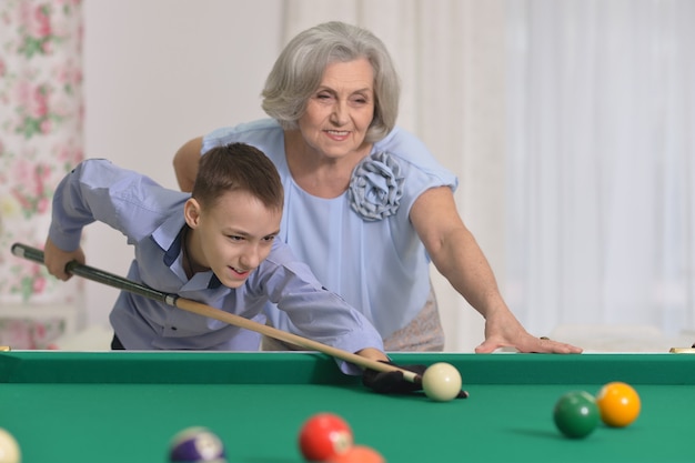 Porträt einer reifen Frau, die Billard mit Enkel spielt