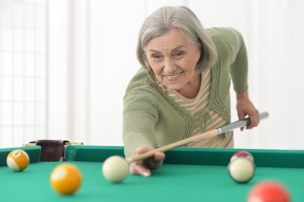 Porträt einer reifen Frau, die Billard spielt