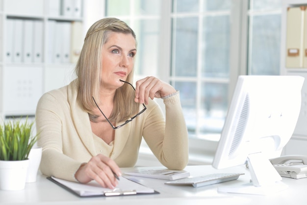 Porträt einer reifen Frau, die Computer im Büro verwendet