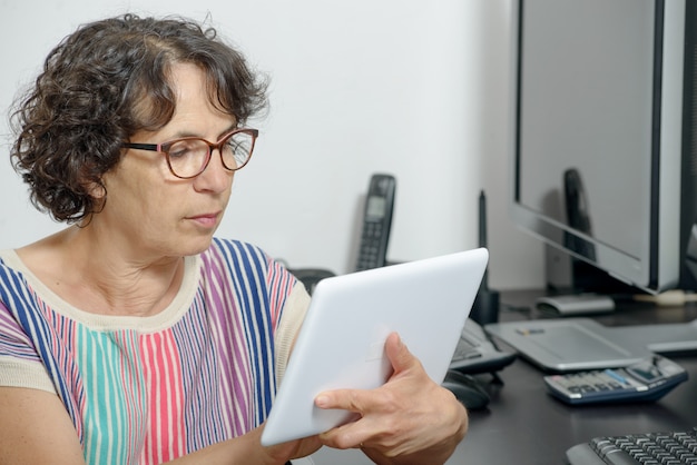 Porträt einer reifen Frau mit einem digitalen Tablett