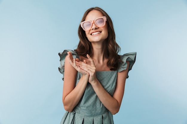 Porträt einer reizenden jungen Frau im Kleid und in der Sonnenbrille