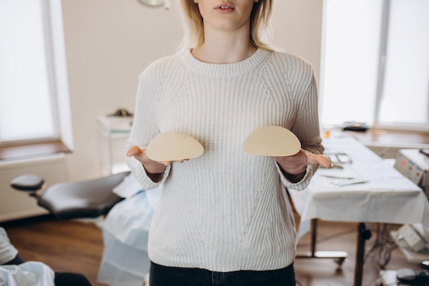 Porträt einer Ärztin, die im Büro eine Brustprothese auswählt