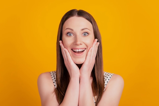 Porträt einer schockierten überraschten Dame mit offenem Mund und Wangen auf gelbem Hintergrund