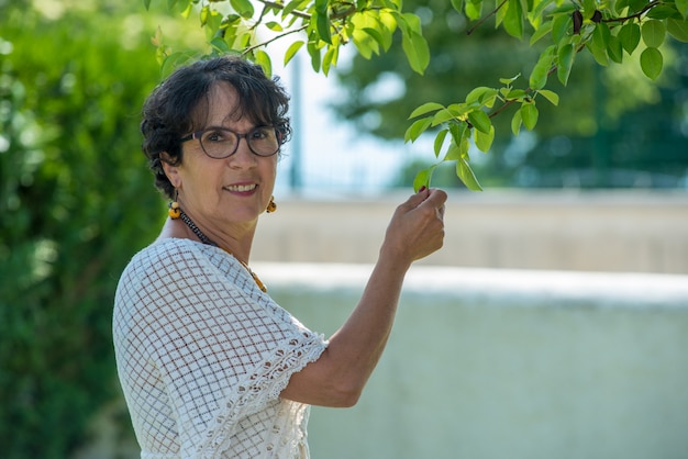 Porträt einer schönen älteren Frau im Garten