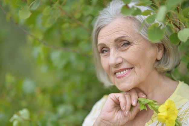 Porträt einer schönen älteren Frau im grünen Park