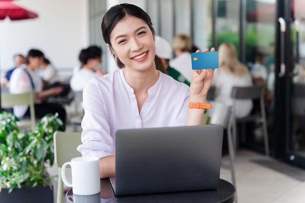 Porträt einer schönen asiatischen Frau, die im Café sitzt