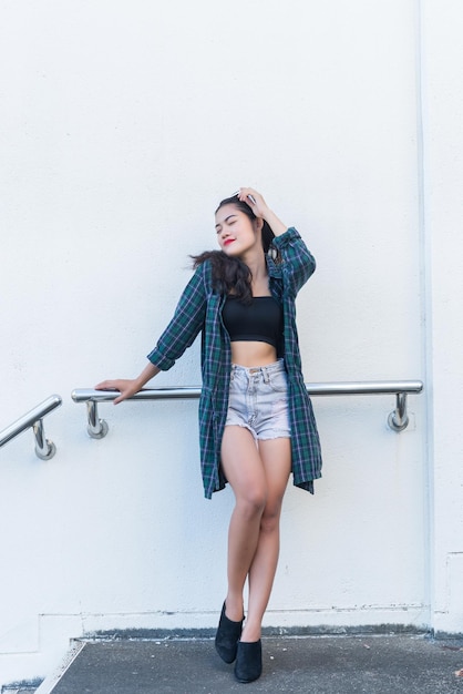 Foto porträt einer schönen asiatischen frauhipster-mädchen auf der treppe zum fotografierenthailänder