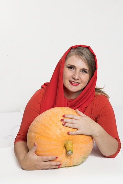 Porträt einer schönen blonden Frau mittleren Alters mit Kürbis bereit für Halloween-Feier-Mockup für Postkarten und Einladungen oder Werbung