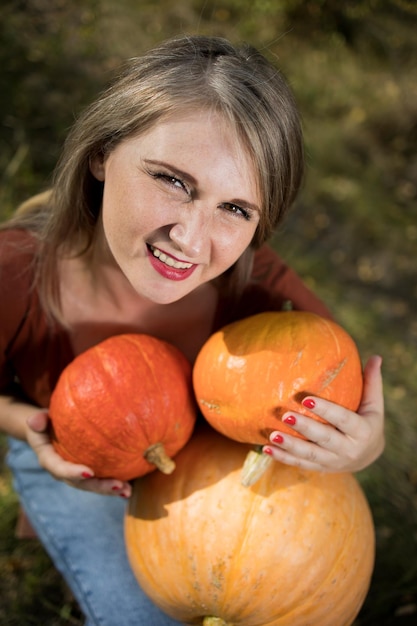 Porträt einer schönen blonden Frau mittleren Alters mit Kürbis bereit für Halloween-Feier-Mockup für Postkarten und Einladungen oder Werbung