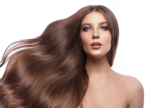 Porträt einer schönen braunhaarigen Frau mit perfekt gelocktem Haar und klassischem Make-up. Schönheitsgesicht und -haare. Bild im Studio auf weißem Hintergrund.