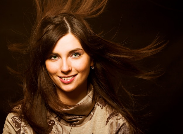 Foto porträt einer schönen brünetten frau mit haaren zum wind