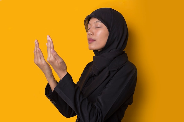 Porträt einer schönen ernsten jungen muslimischen Frau, die einen schwarzen Hijab trägt