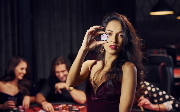 Porträt einer schönen Frau Gruppe eleganter junger Leute, die zusammen im Casino Poker spielen