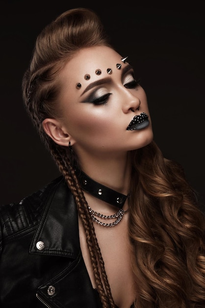 Porträt einer schönen Frau in einem Rockstilbild mit kreativem Make-up und Frisur.