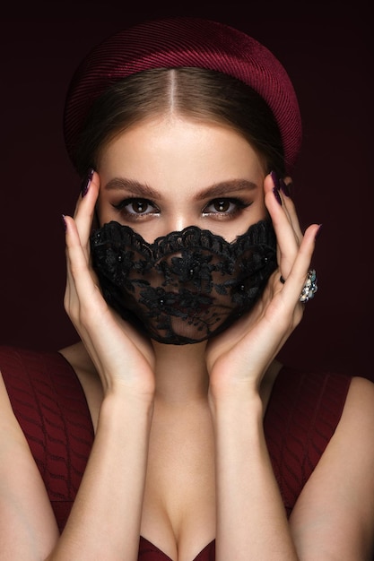 Porträt einer schönen Frau in einer schwarzen Spitzenmaske und im klassischen Make-up-Maskenmodus während der Covid-Pandemie