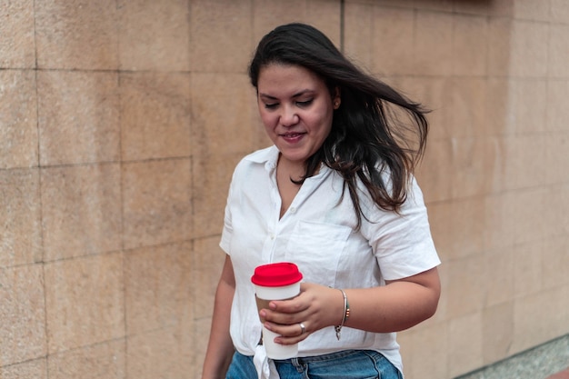 Porträt einer schönen Frau mit einem Glas Kaffee in der Stadt.