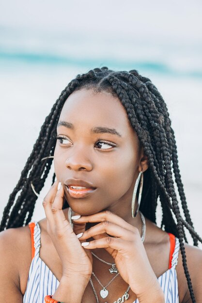 Porträt einer schönen jungen Afrikanerin in der Nähe von Palmen am Strand hautnah