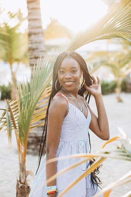 Porträt einer schönen jungen Afrikanerin in der Nähe von Palmen am Strand hautnah