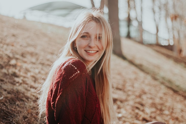 Porträt einer schönen jungen Frau, die auf dem Feld sitzt