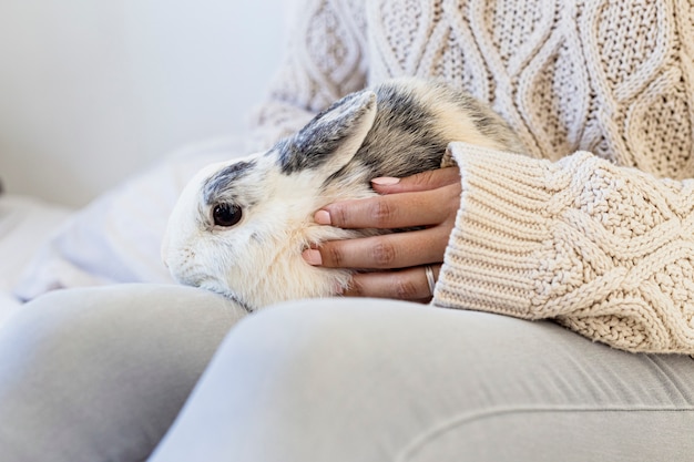 Porträt einer schönen jungen Frau, die ein Kaninchen streichelt