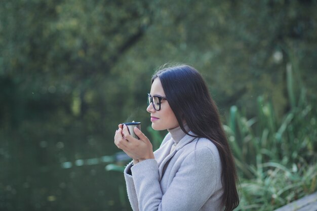 Porträt einer schönen jungen Frau, die einen Mantel draußen trägt