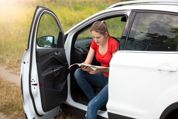 Porträt einer schönen jungen Frau hat sich beim Autofahren verirrt