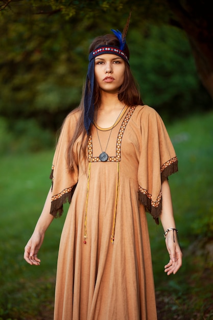 Porträt einer schönen jungen Frau im traditionellen Kleid, lokalisierter grüner Hintergrund