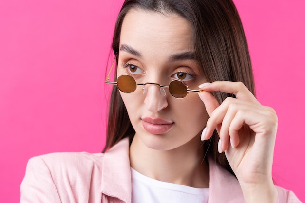 Porträt einer schönen jungen Frau in rosa Jacke, die isoliert auf rotem Hintergrund denkt