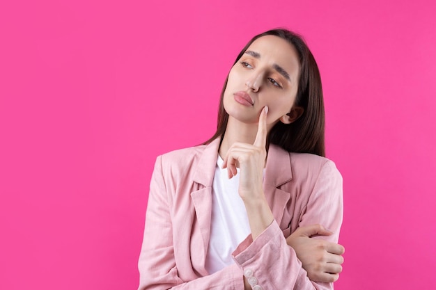 Porträt einer schönen jungen frau in rosa jacke, die isoliert auf rotem hintergrund denkt