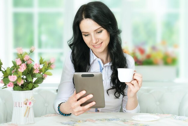 Porträt einer schönen jungen Frau mit digitalem Tablet