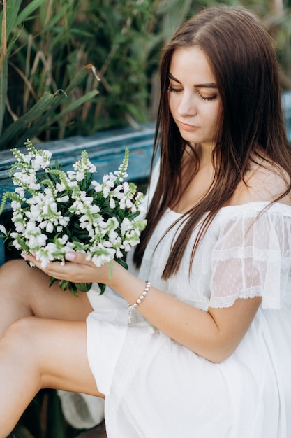 Porträt einer schönen jungen Frau mit einem Strauß Wildblumen