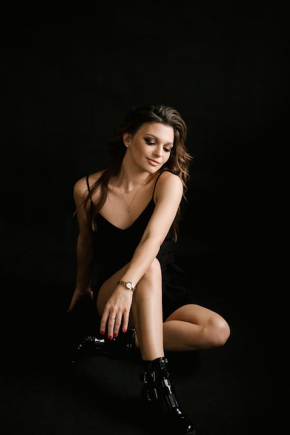 Porträt einer schönen jungen sexy Mädchenfrau in einem Studio auf einem schwarzen Hintergrund