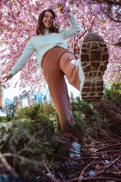 Porträt einer schönen kaukasischen Frau mit blühenden Sakura-Kirschbäumen