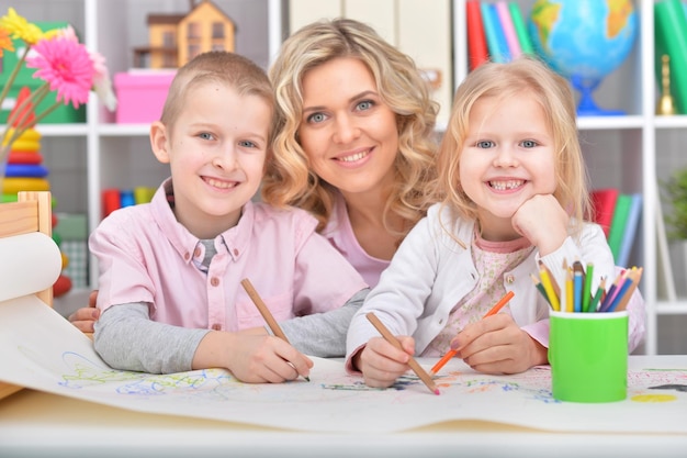 Porträt einer schönen Mutter mit Tochter, die mit bunten Bleistiften zeichnet