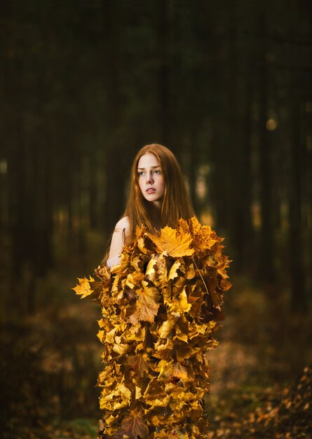Porträt einer schönen rothaarigen Frau, Herbstlaubkleid im Herbstpark