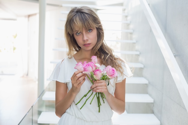 Porträt einer schönen traurigen Frau mit Blumen auf Treppen