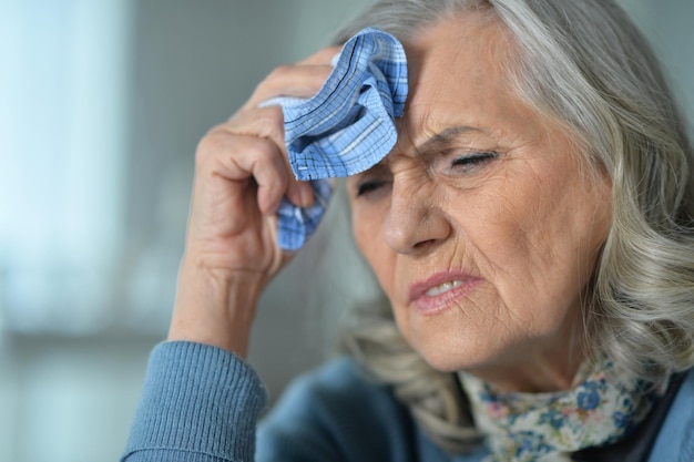 Porträt einer schönen traurigen Seniorin mit Kopfschmerzen