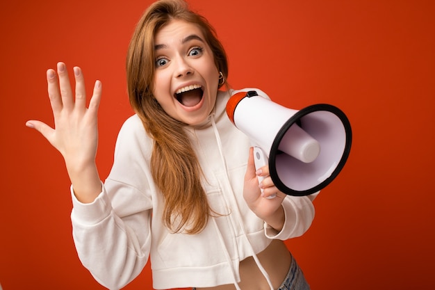 Foto porträt einer schönen, ziemlich positiven, glücklichen, entzückenden dunkelblonden jungen frau mit aufrichtigen emotionen