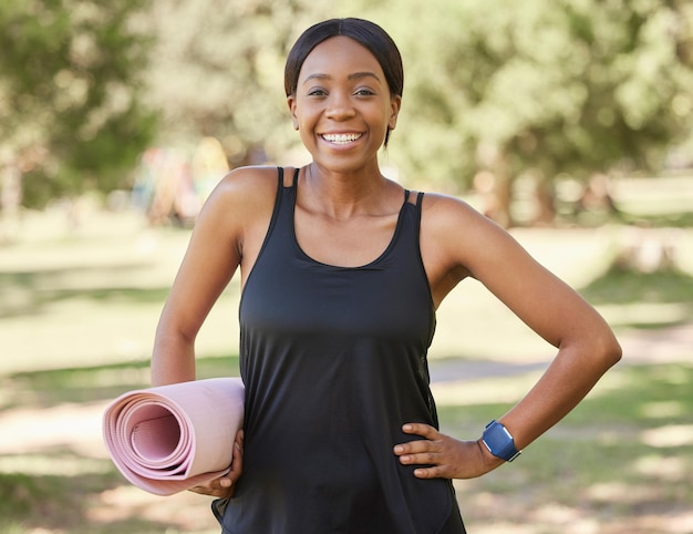 Porträt einer schwarzen Frau im Park mit Yogamatte und Lächeln in der Natur für Gesundheit und Fitness, Denkweise und Pflege. Trainieren Sie Zen und Yoga, glückliches Gesicht auf Frau, die bereit ist für Pilates-Training auf Gras in der Sommersonne