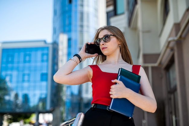 Porträt einer selbstbewussten Frau in eleganter Freizeitkleidung und mit einem Smartphone auf einer Stadtstraße Manager in einer Großstadt Kommunikation mit Menschen im Internet