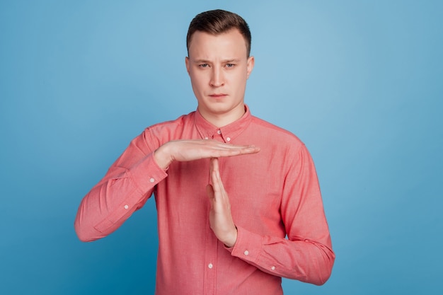 Porträt einer selbstbewussten Schiedsrichter-Show Break Geste Look-Kamera auf blauer Wand