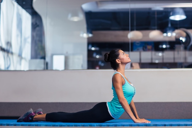 Porträt einer Sportfrau, die Yogaübungen im Fitnessstudio macht