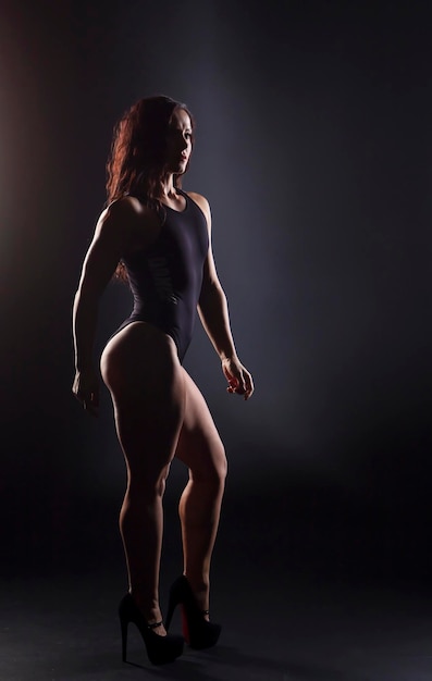 Porträt einer starken Fitness-Bodybuilderin mit schwarzem Haar und gebräuntem Körper
