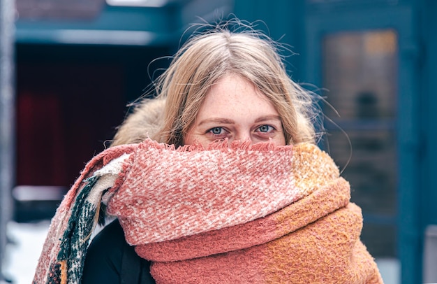 Foto porträt einer süßen jungen frau, die im winter in einen schal gehüllt ist